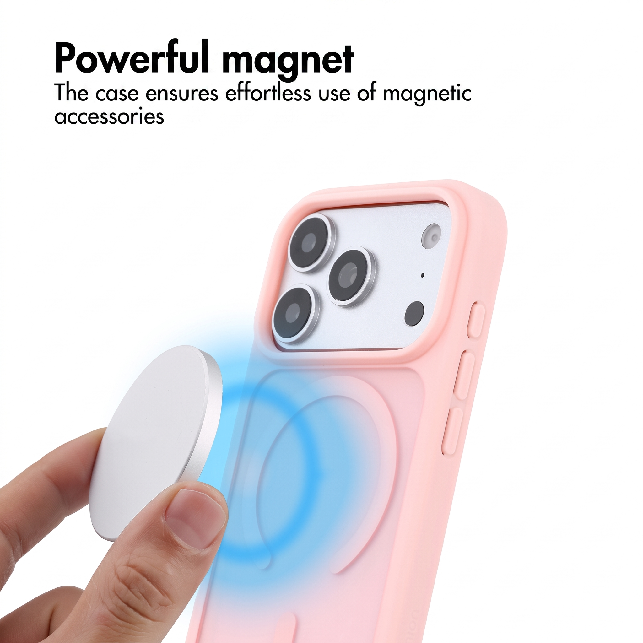 Mano tiene un magnete argentato vicino a cover rosa con fotocamera.