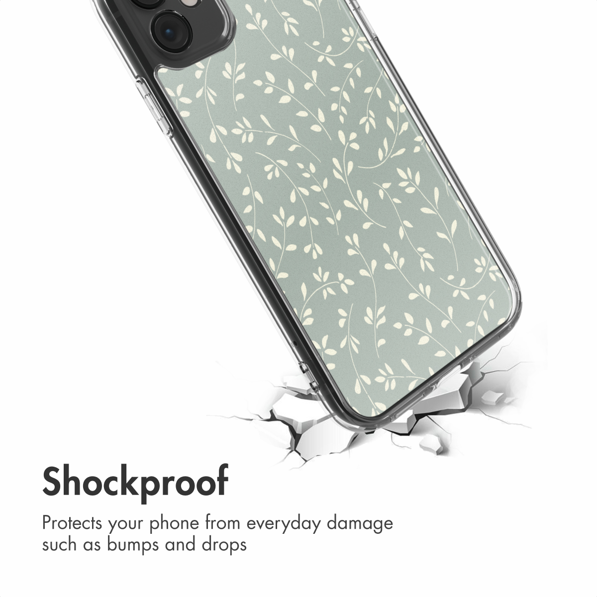 Una funda de móvil antichoque con delicadas hojas en verde salvia, sobre una superficie blanca agrietada.