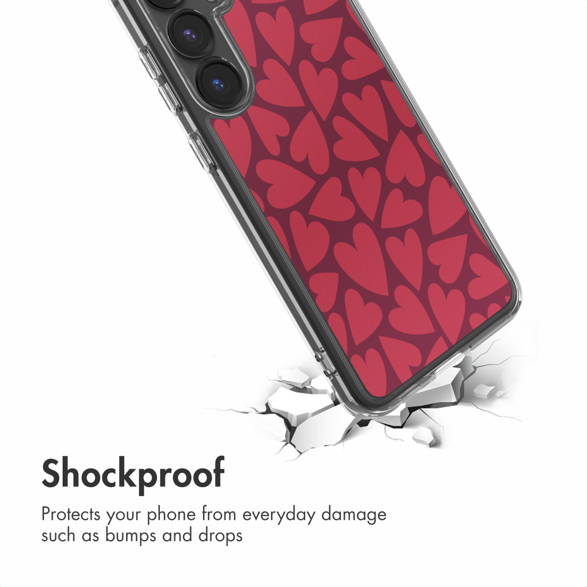 Un smartphone con funda de corazones rojos sobre una superficie blanca agrietada. El texto dice Resistente a golpes.