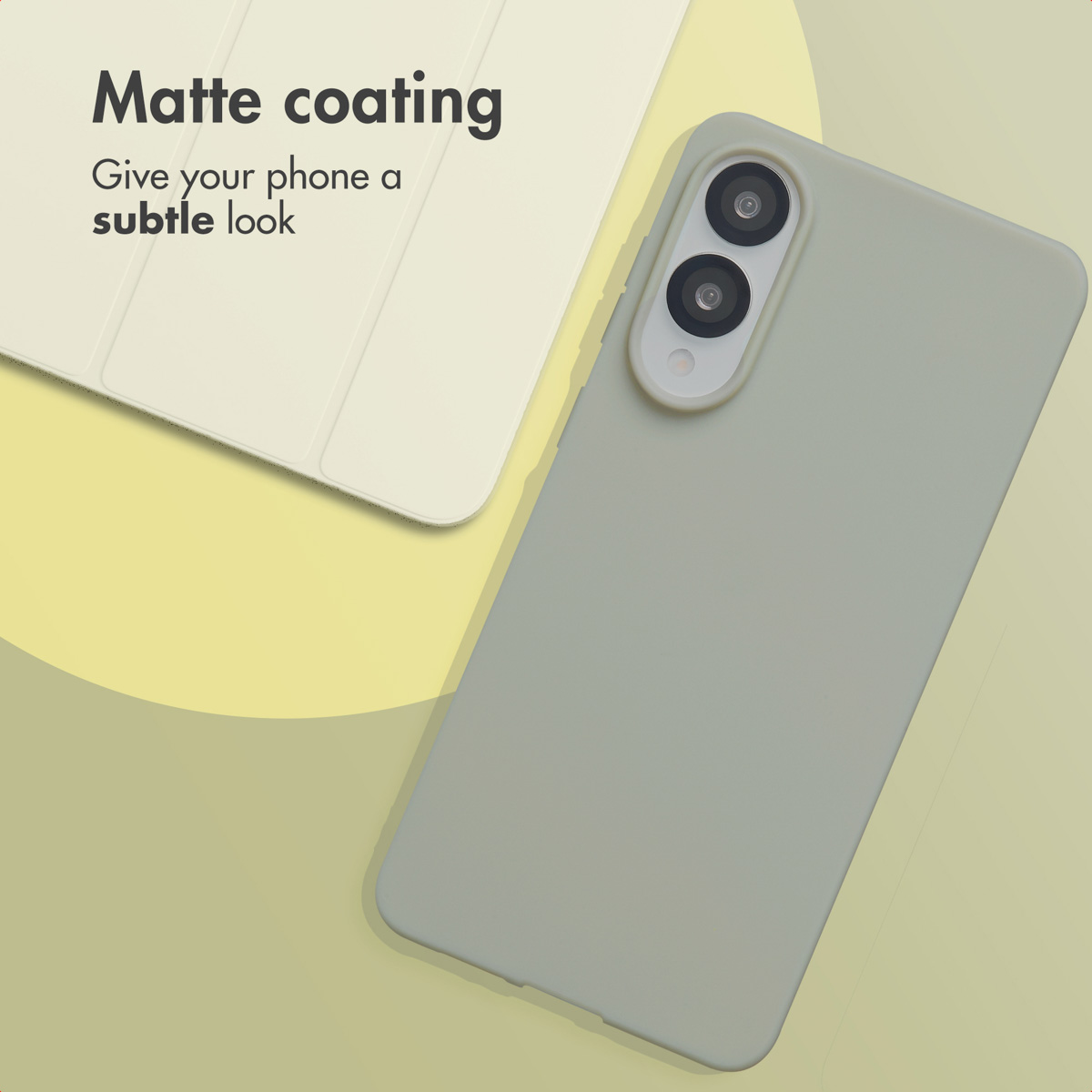 Un smartphone verde mate con funda descansa junto a una funda de tablet clara sobre fondo beige.