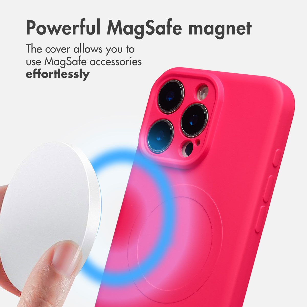Una mano tiene un accessorio magnetico bianco vicino a una cover rosa con MagSafe.
