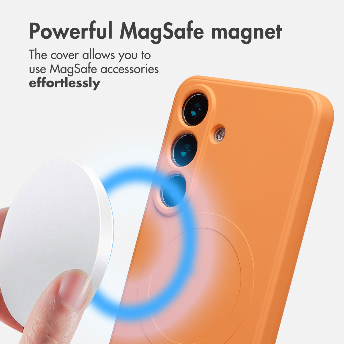 Eine Hand hält eine MagSafe-Ladestation nah an eine orange Handyhülle auf weißem Hintergrund.