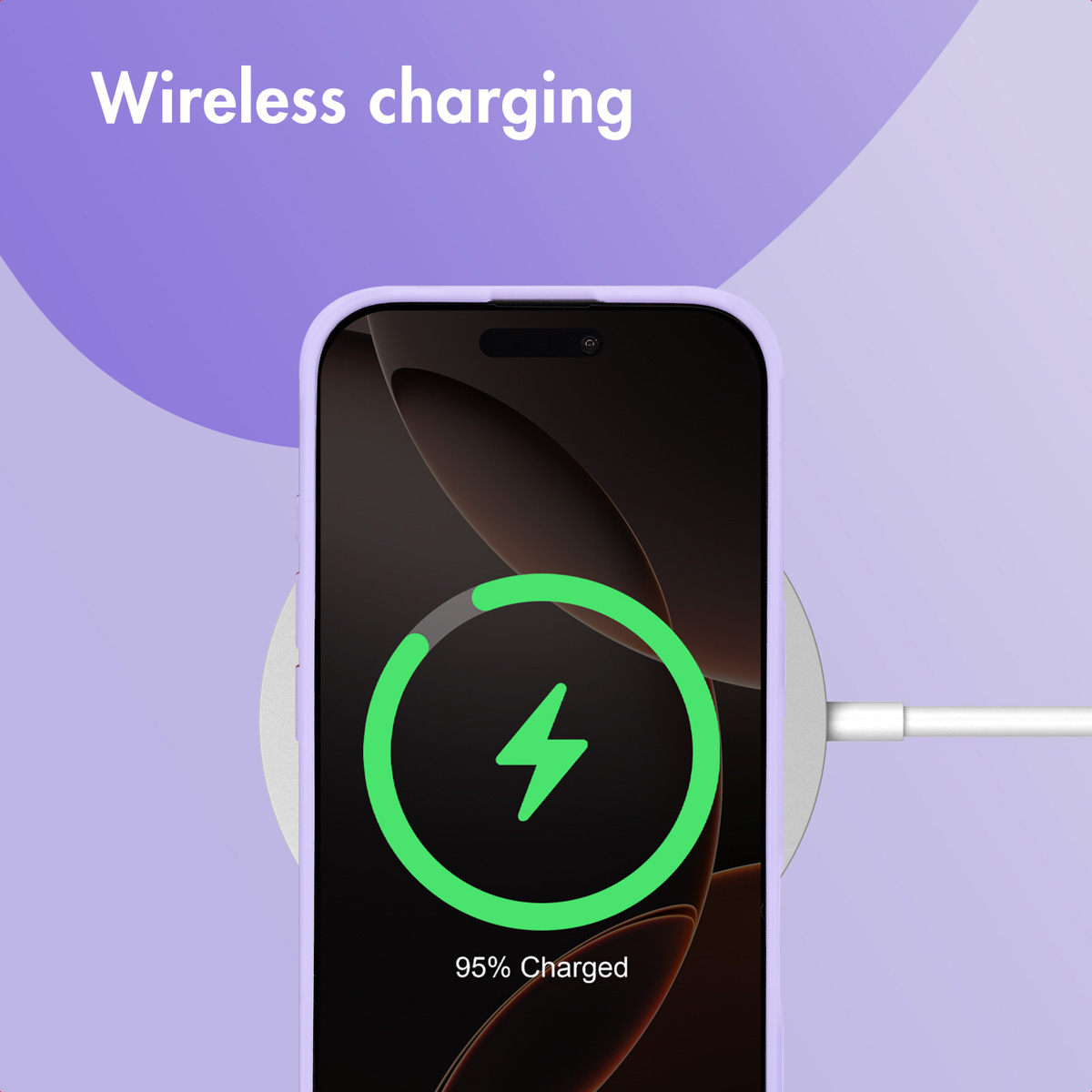 Un smartphone dans une coque violette en charge sans fil sur fond violet.