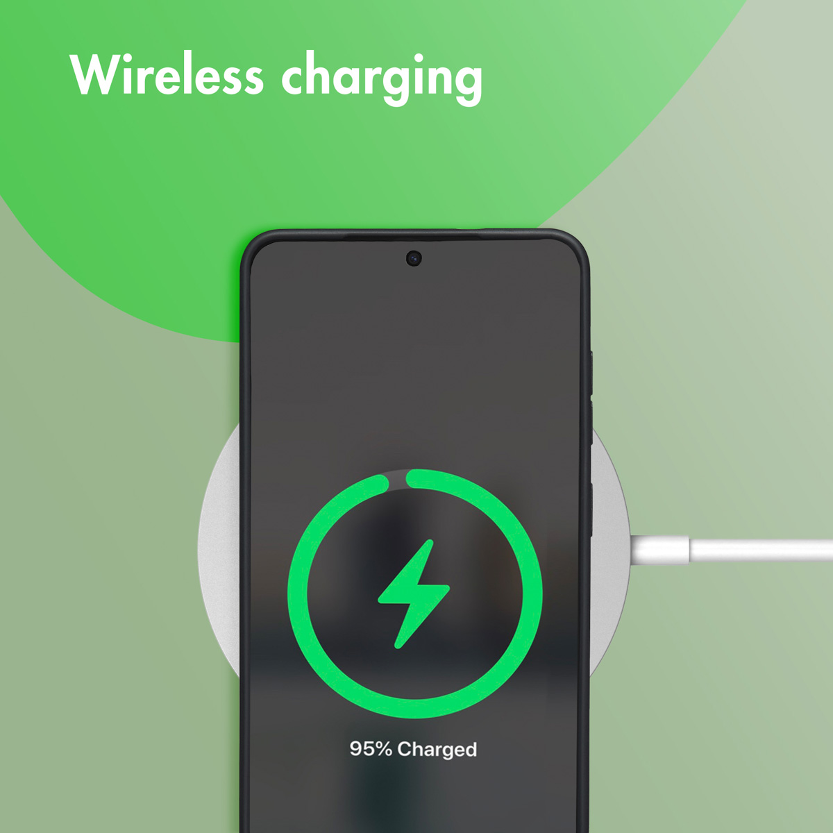Un smartphone se carga de forma inalámbrica en una base redonda sobre fondo verde.