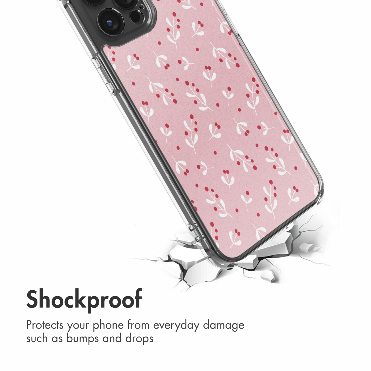 Funda de móvil rosa con ramitas blancas y bayas rojas, situada sobre una superficie blanca agrietada.