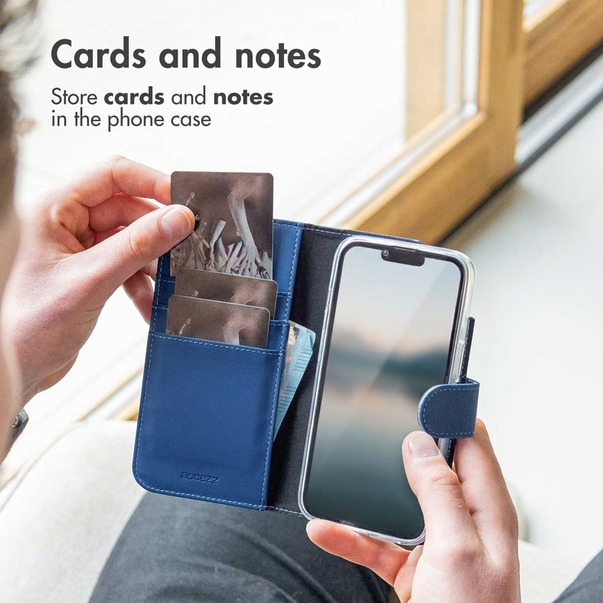Persona che tiene in mano una custodia in pelle blu con carte e banconote.