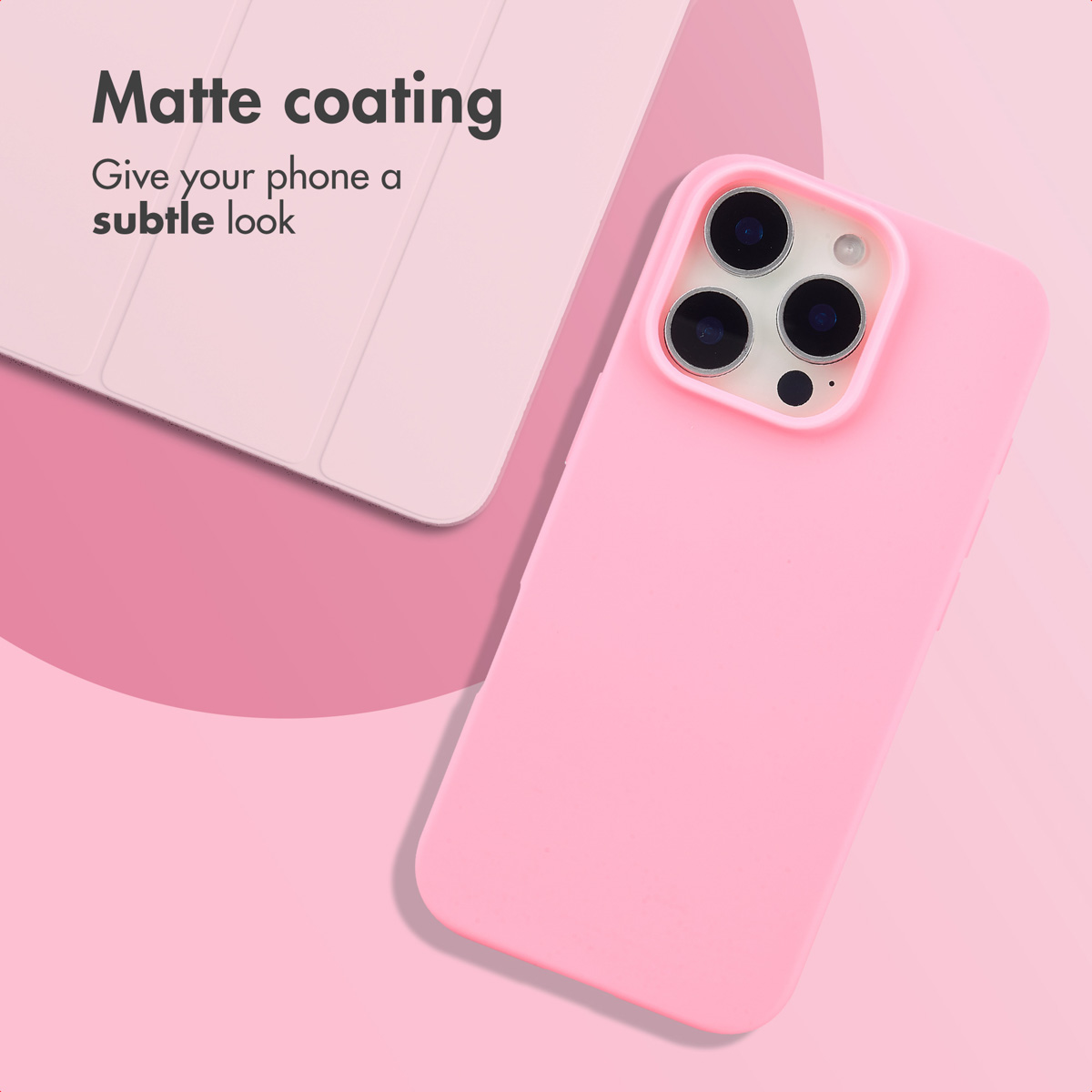 Een roze smartphone in een matte hoes ligt op een roze achtergrond naast een tablethoes.