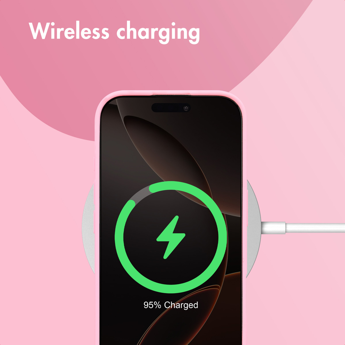 Een roze smartphone draadloos opgeladen op een pad tegen een roze achtergrond, scherm toont 95% opgeladen.