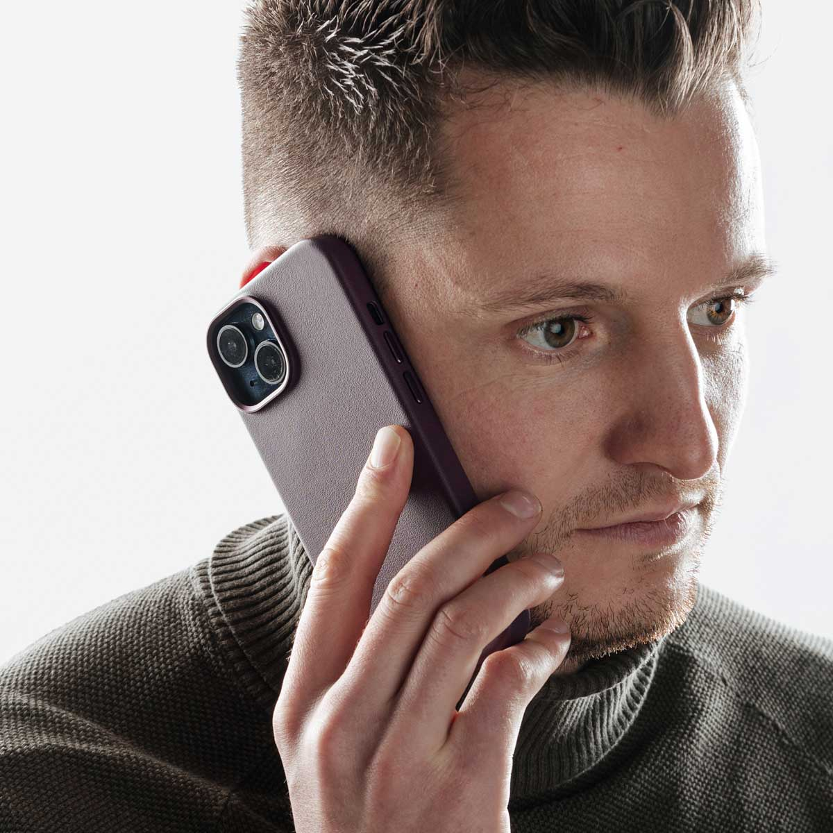 Un uomo parla al telefono con uno smartphone viola.