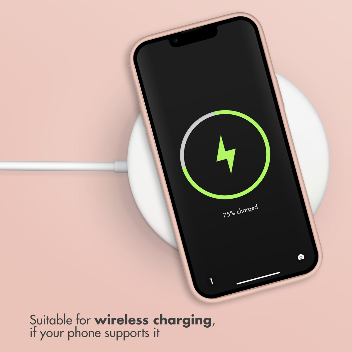 Smartfon ładuje się bezprzewodowo na białej podkładce na różowym tle.
