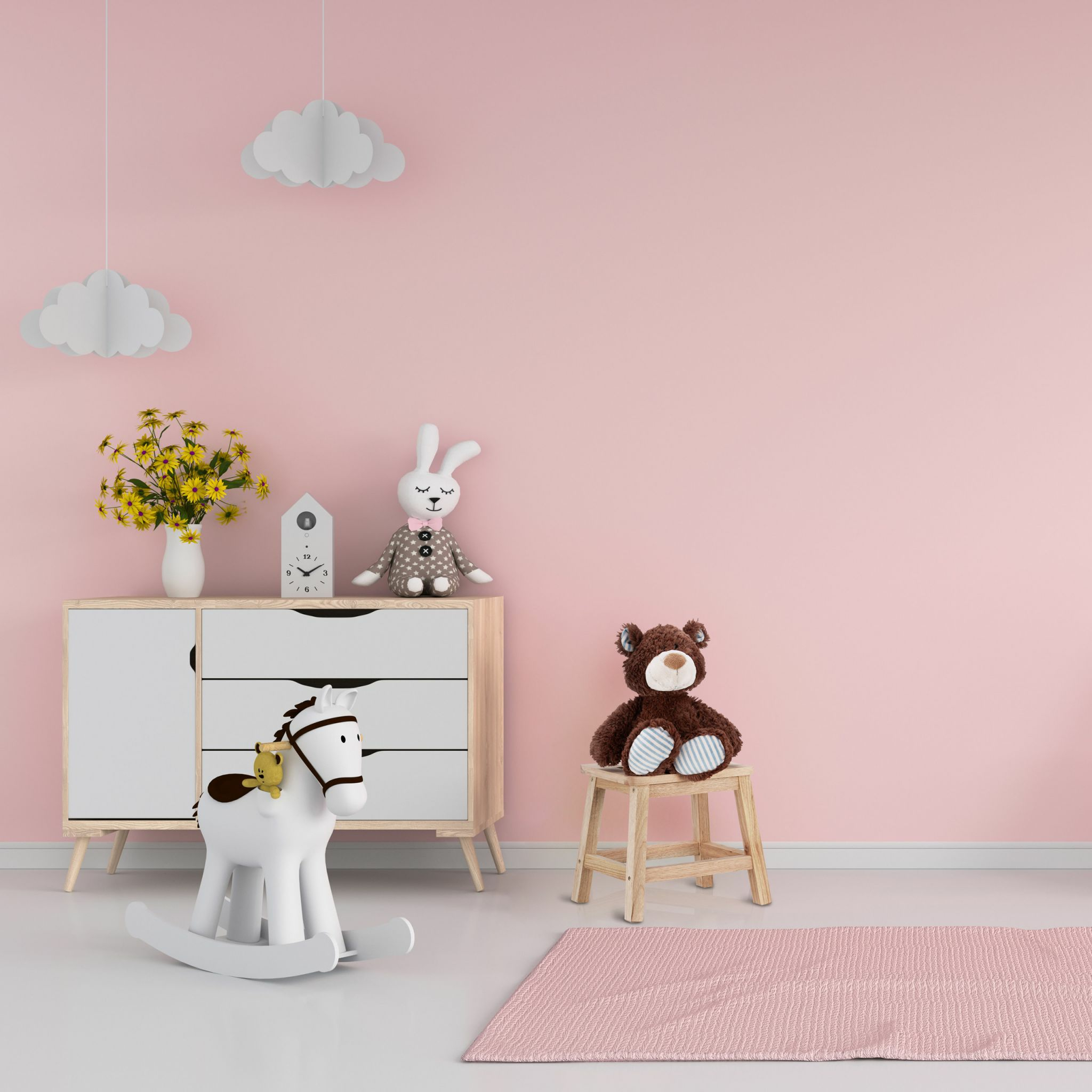 Rosa Kinderzimmer mit weißem Schrank, Schaukelpferd, Plüschtieren und rosa Teppich.