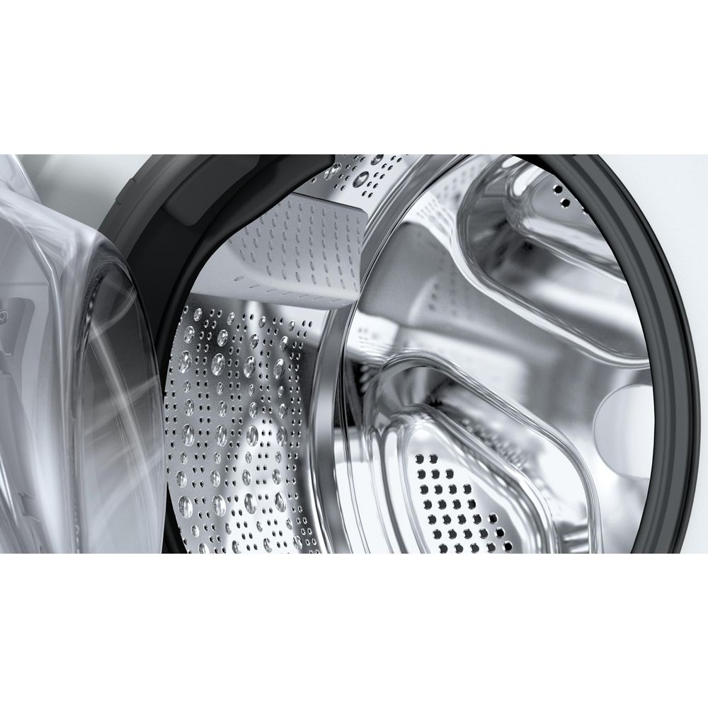 Gros plan sur le tambour en acier inoxydable d'un lave-linge avec une porte ouverte et des gouttes.