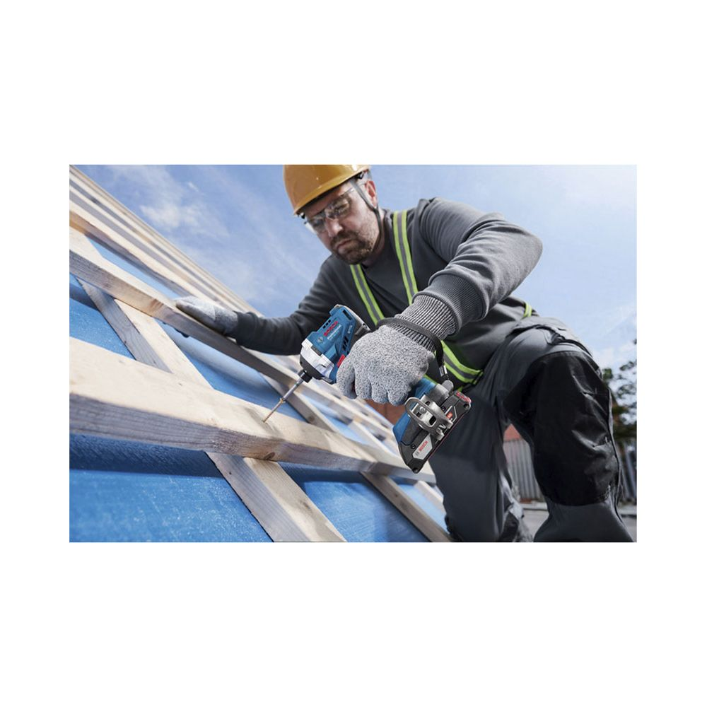 Ein Arbeiter in Schutzkleidung nutzt einen Akkuschrauber auf einem Holzdach.
