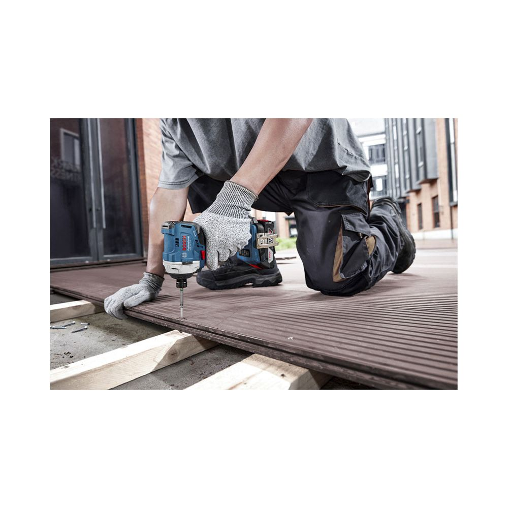 Ein Arbeiter kniet auf Holzplanken und schraubt diese mit einem blauen Akkuschrauber fest.