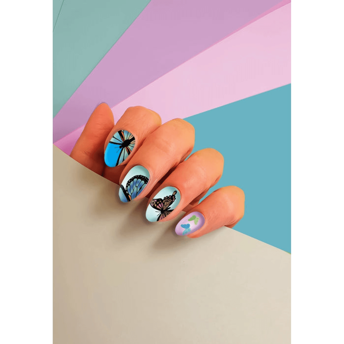 Mano con uñas decoradas con mariposas sobre un fondo colorido.