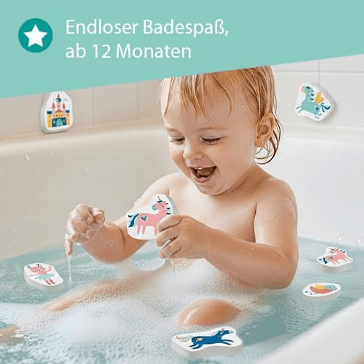 Niño pequeño riendo mientras se baña en una tina con espuma, jugando con juguetes de baño de espuma coloridos.