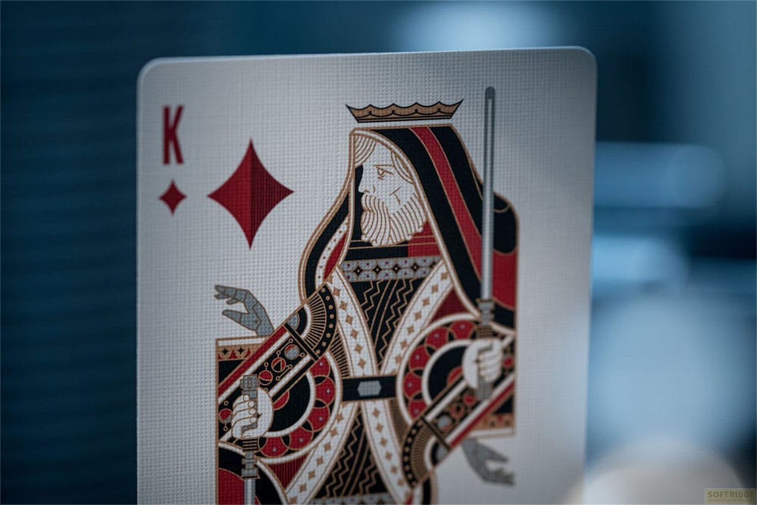 Une carte à jouer représentant le Roi de Carreau en noir, rouge et blanc, sur un fond flou.