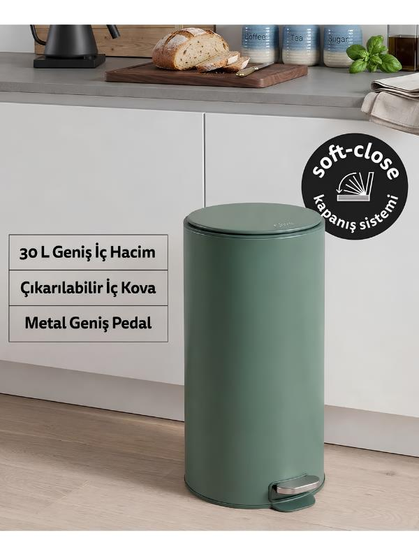 Modern bir mutfakta yeşil silindirik pedallı çöp kovası ve ürün yazıları.