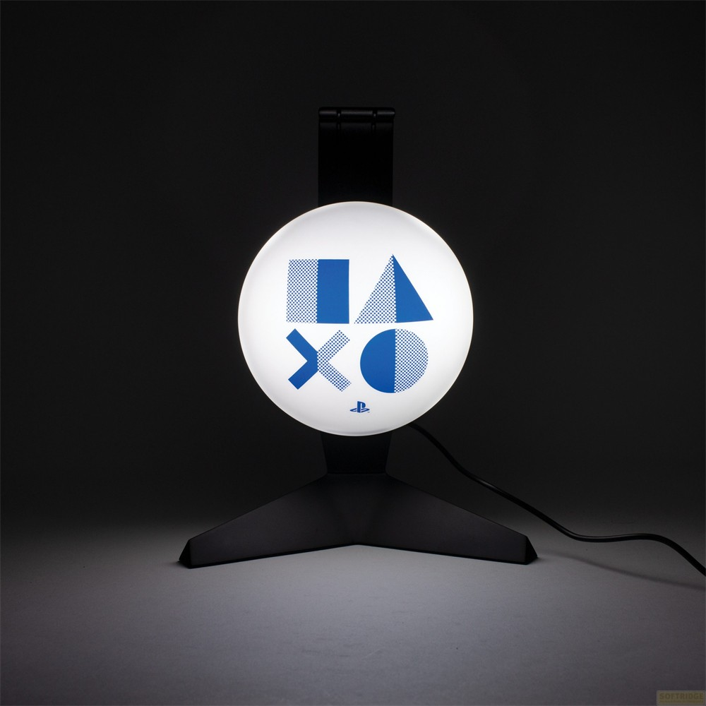 Podświetlana, okrągła lampa PlayStation na czarnym stojaku na ciemnym tle.