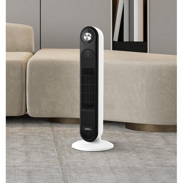 Un moderno ventilador de torre blanco y negro sobre una alfombra en una habitación luminosa.