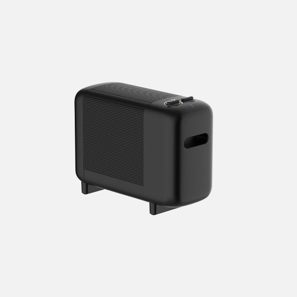 Un dispositivo electrónico negro y rectangular con un panel lateral de malla sobre pequeñas patas.