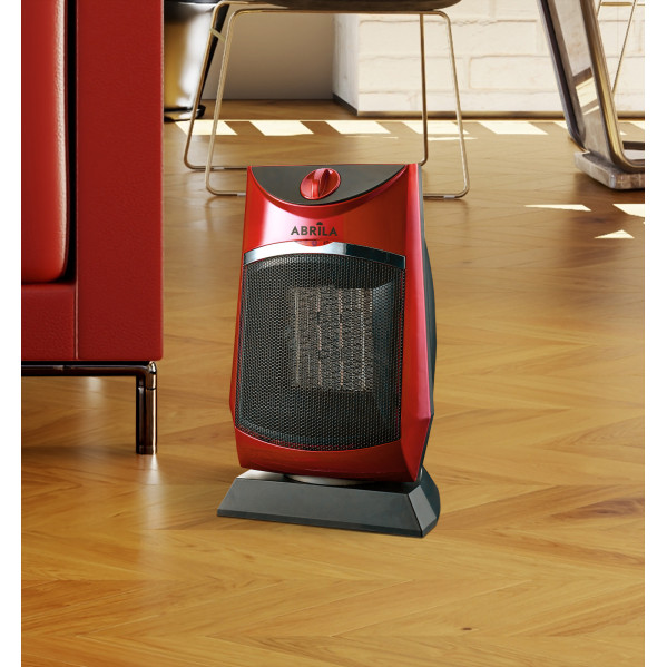 Un calefactor eléctrico rojo y negro ABRILA colocado sobre un suelo de madera.