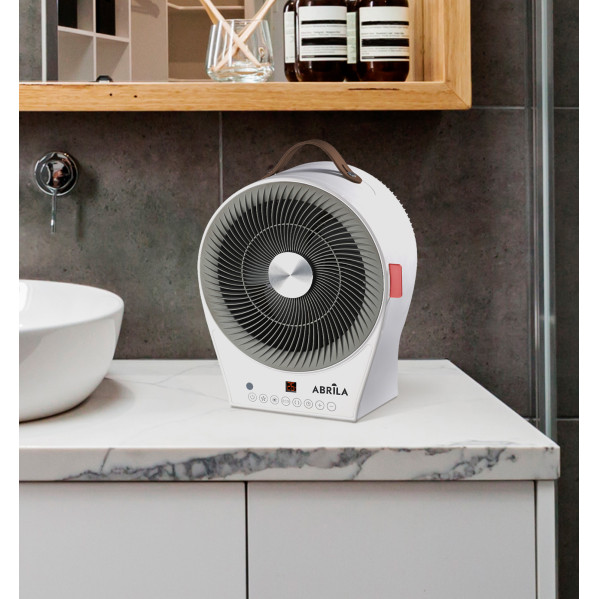 Un calefactor eléctrico portátil blanco y gris con asa marrón sobre un mostrador de baño.