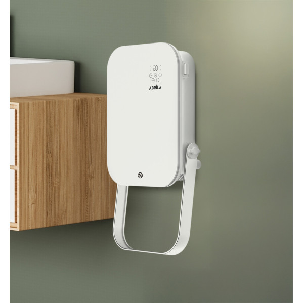 Un calefactor blanco Abrila cuelga de una pared verde junto a un armario de madera.