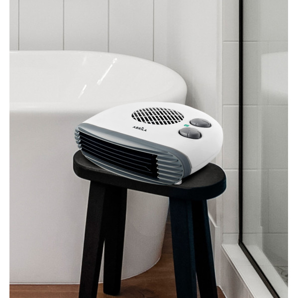 Un calefactor blanco se encuentra en un taburete negro en un baño junto a una bañera.