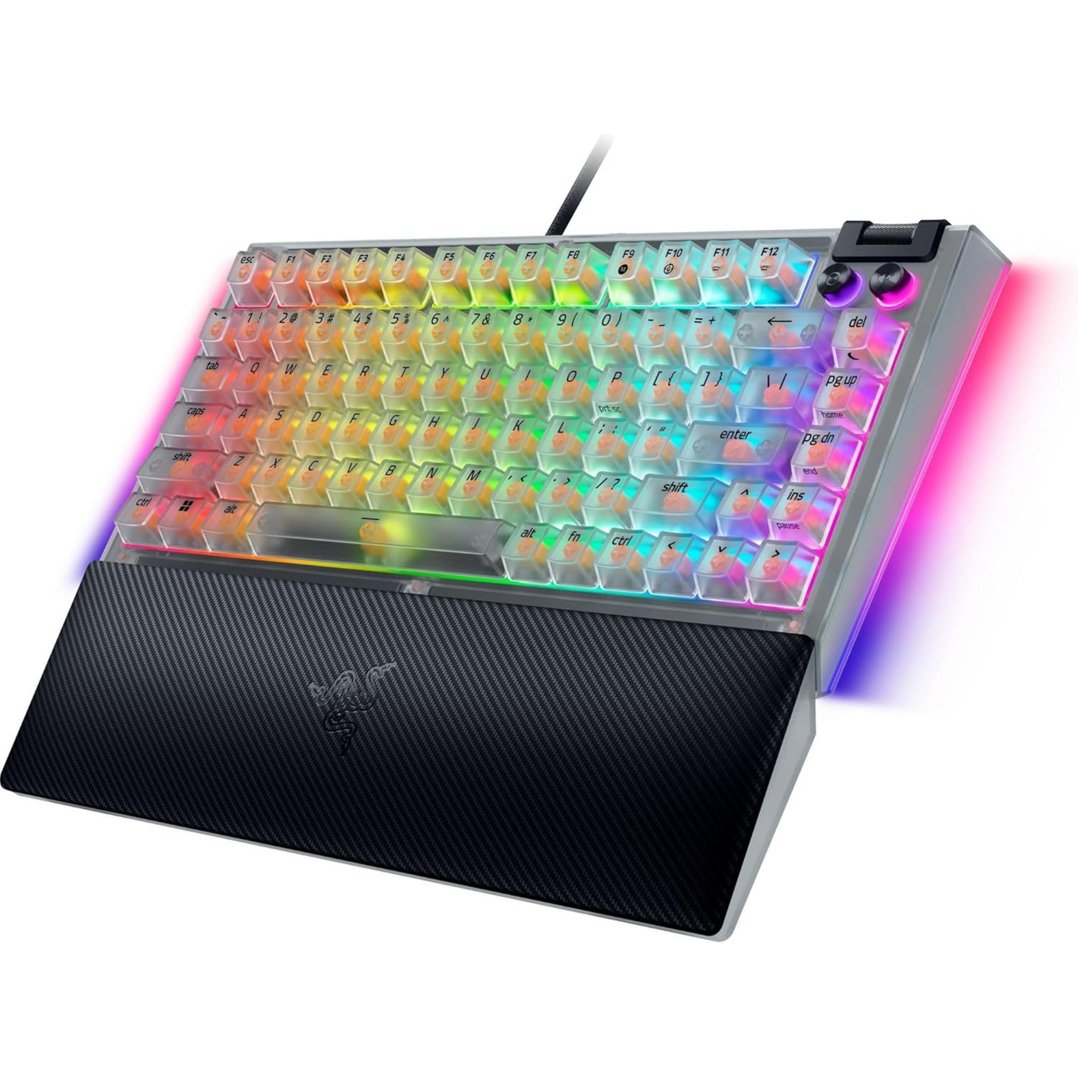 Tastiera meccanica compatta con tasti trasparenti, retroilluminazione RGB colorata e poggiapolsi nero testurizzato.