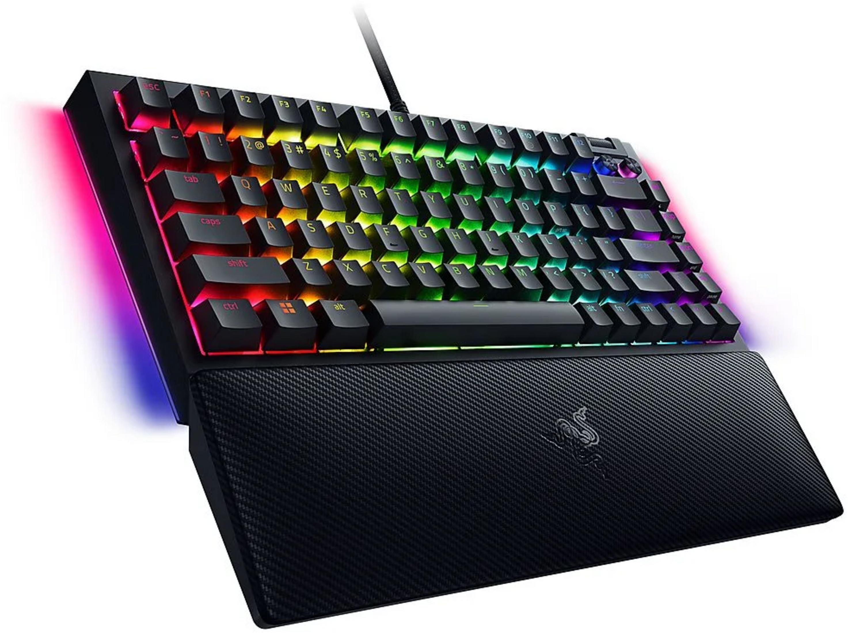 Un teclado para juegos negro con retroiluminación RGB y un reposamuñecas acolchado adjunto.