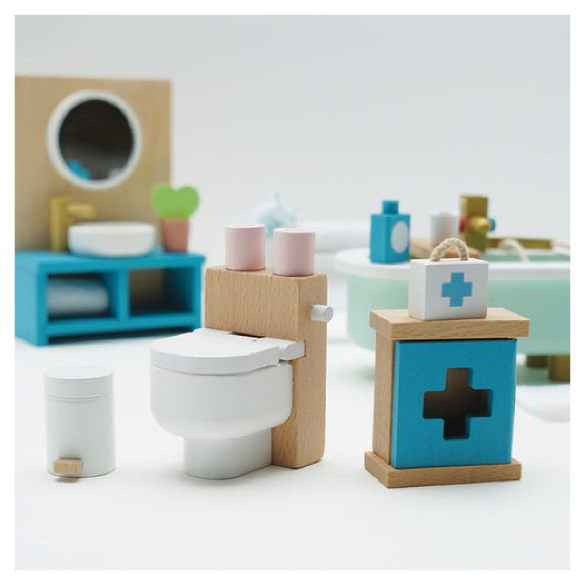 Set da bagno giocattolo in legno con lavandino, WC, vasca e mobiletto medico su sfondo bianco.