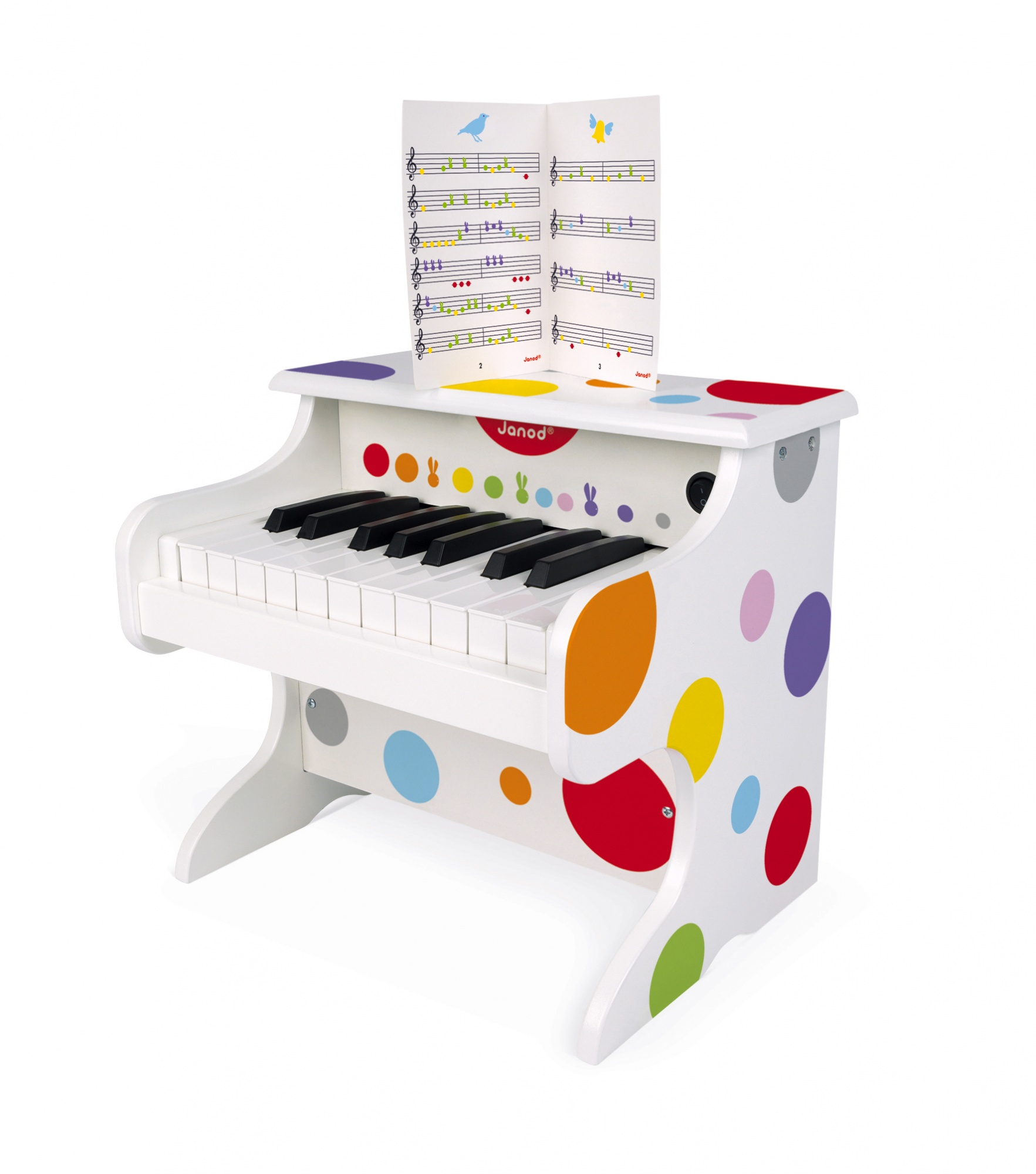 Un piano jouet blanc à pois colorés, des touches noires et blanches, et une partition de musique colorée.