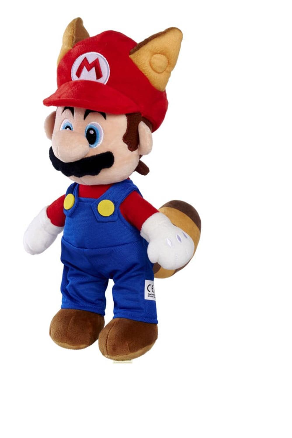 Ein Plüsch-Tanooki-Mario-Spielzeug mit Fuchsohren, roter Mütze, blauer Latzhose und braunem Schwanz vor weißem Hintergrund.