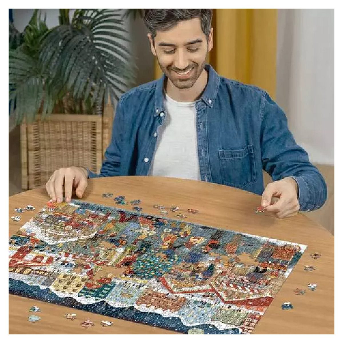 Ein lächelnder Mann sitzt an einem Holztisch und setzt ein großes Puzzle zusammen.