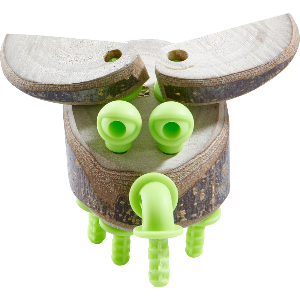 Eine Holzfigur mit grünen Kunststoffverbindern, zwei Holzhohren, runden Augen und einer rüsselartigen Nase.