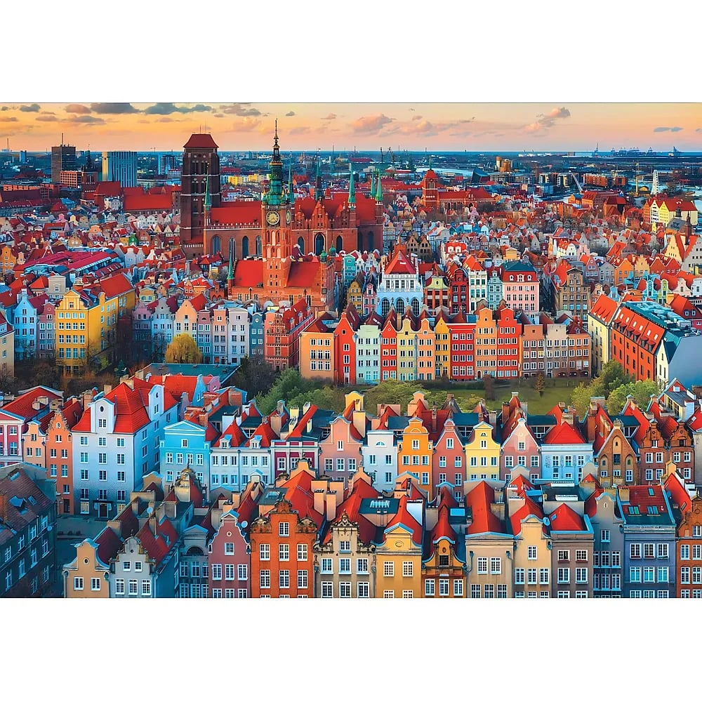 Blick auf eine farbenfrohe europäische Altstadt mit vielen historischen roten Ziegeldächern bei Sonnenuntergang.