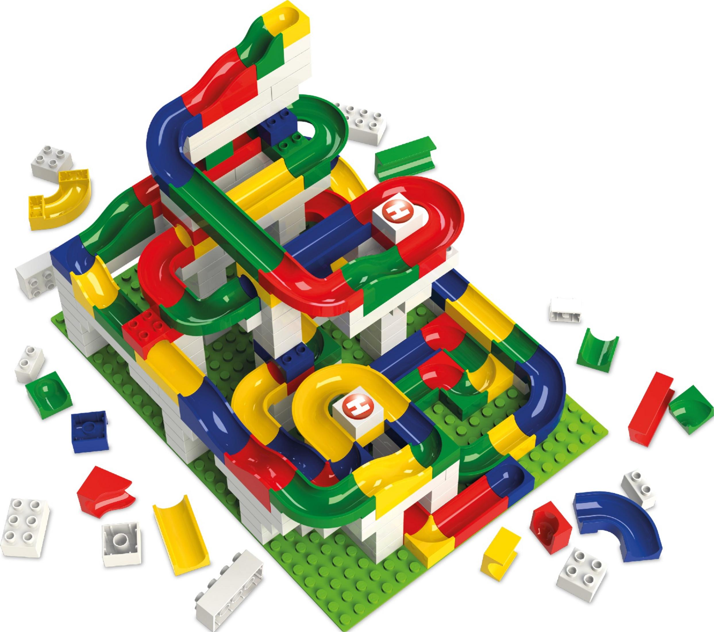 Circuit de billes en plastique coloré avec des rails sur une plaque de base verte, entouré de pièces détachées.