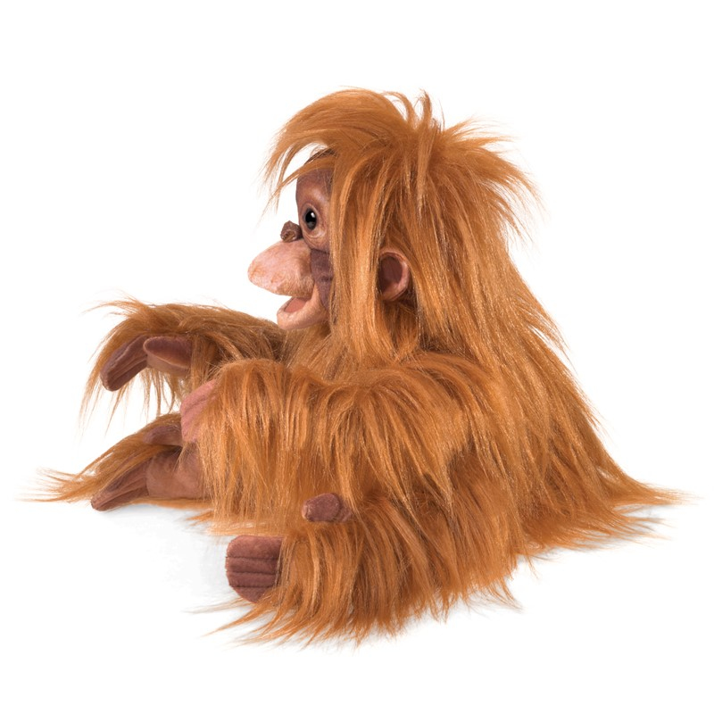 Une marionnette  à main orang-outan orange et duveteuse avec une peau marron sur fond blanc.