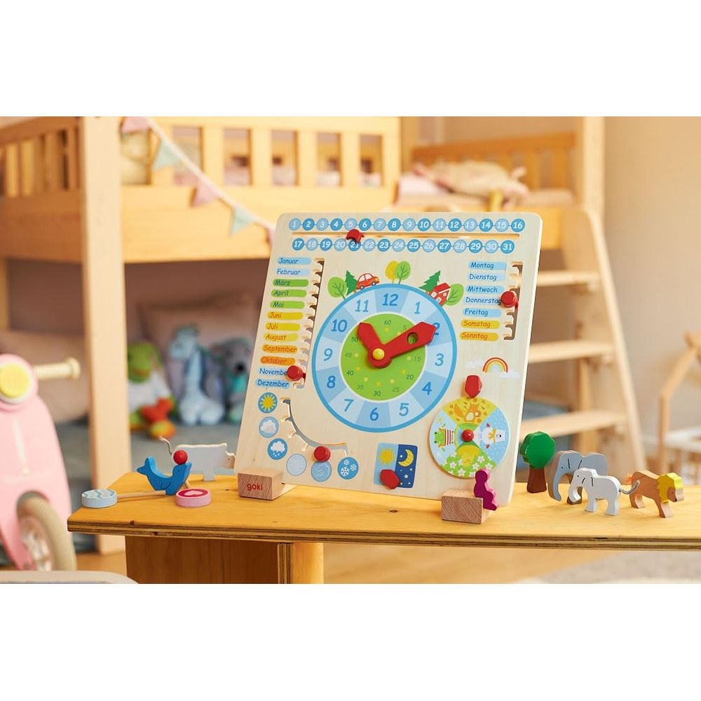 Un calendrier et une horloge en bois colorés sont posés sur une table dans une chambre d'enfant.