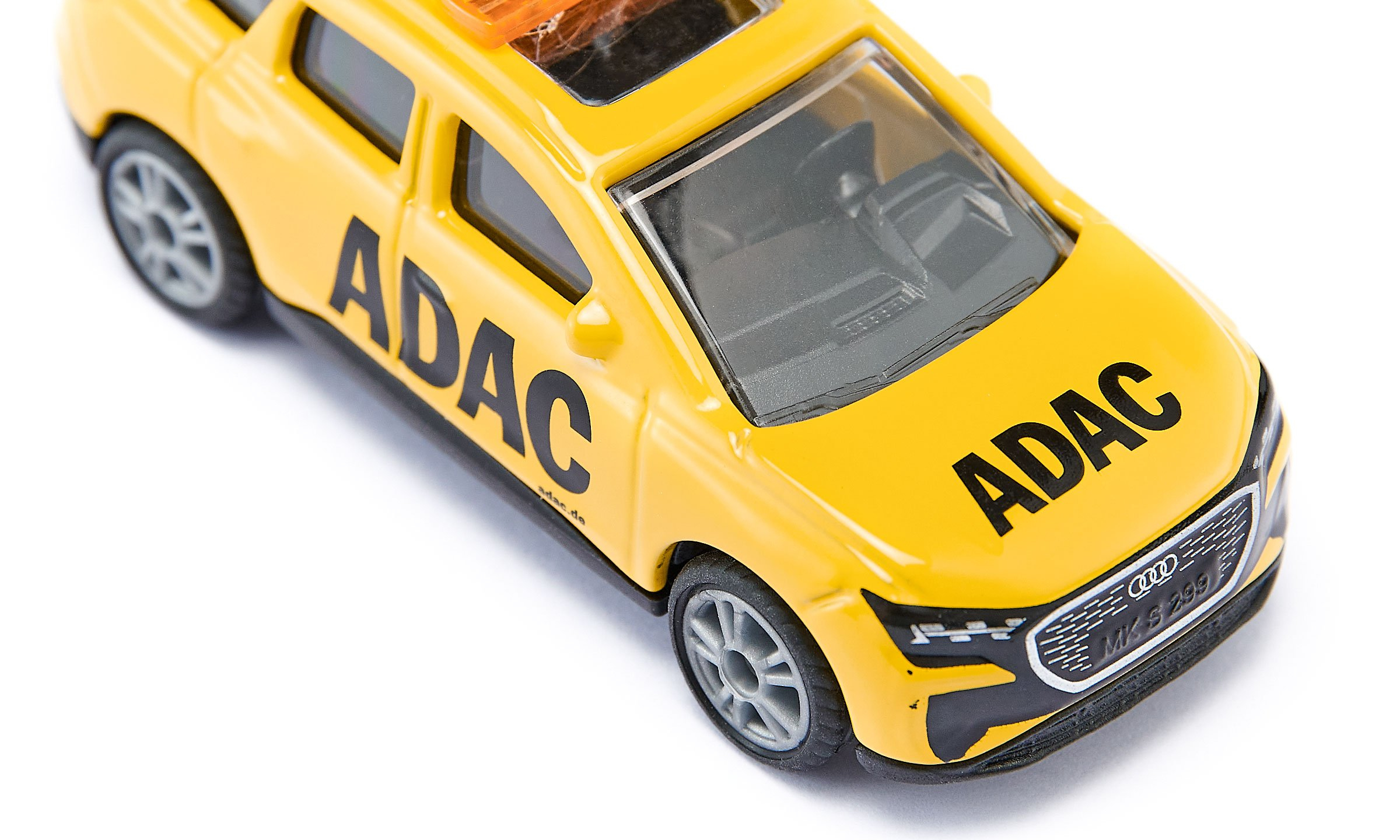 Une voiture jouet ADAC jaune sur fond blanc avec des inscriptions noires sur le côté et le capot.