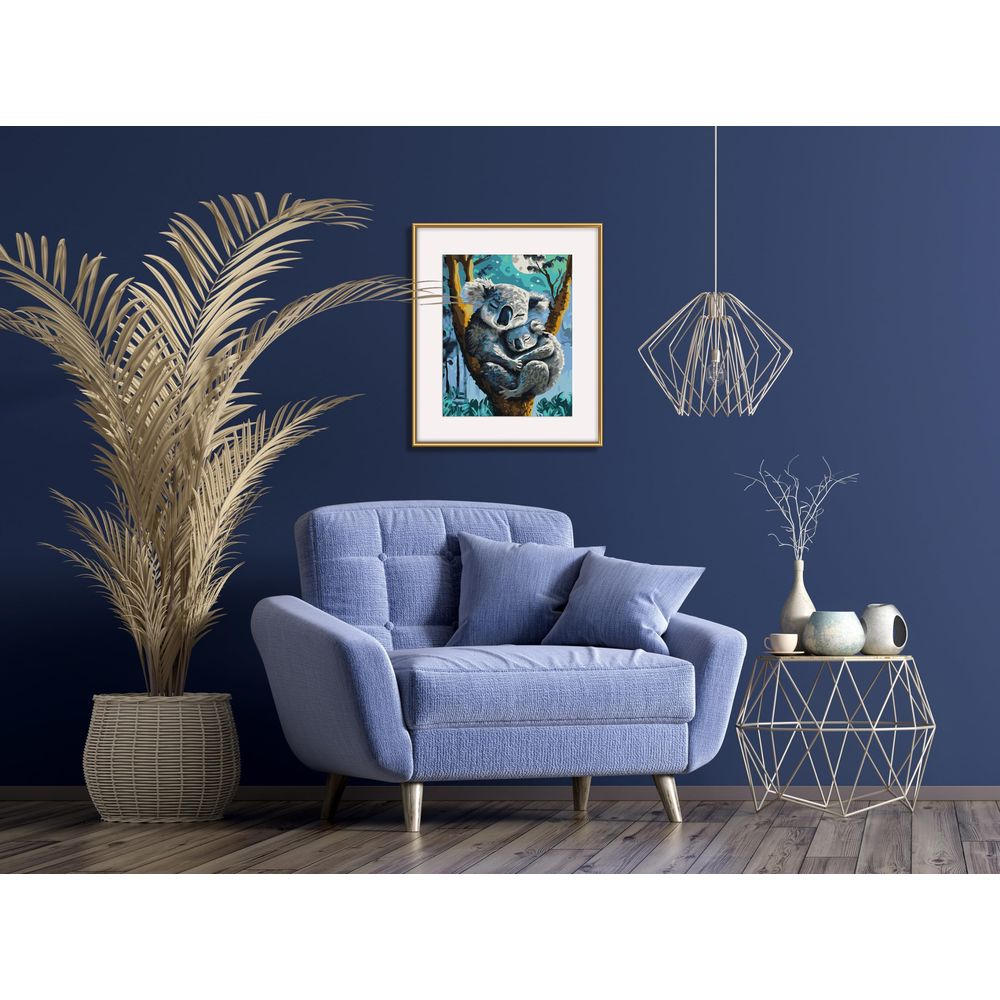 Ein gemütliches blaues Zimmer mit Sessel, koala-Bild, großer Palme und einem geometrischen Beistelltisch.