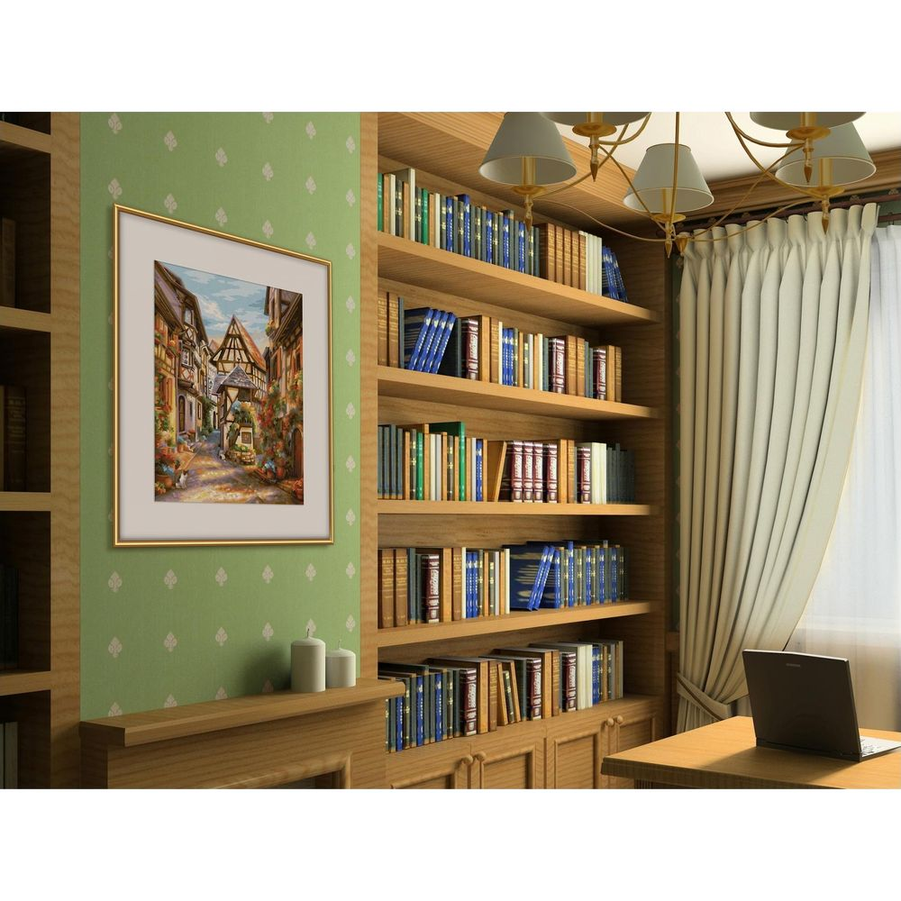 Ein gerahmtes Bild einer europäischen Gasse hängt an einer grünen Wand neben einem vollen Bücherregal.