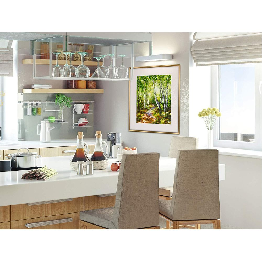 Moderne Küche mit weißer Kochinsel, gepolsterten Barhockern, Hängeregal für Gläser und einem großen Waldbild an der Wand.
