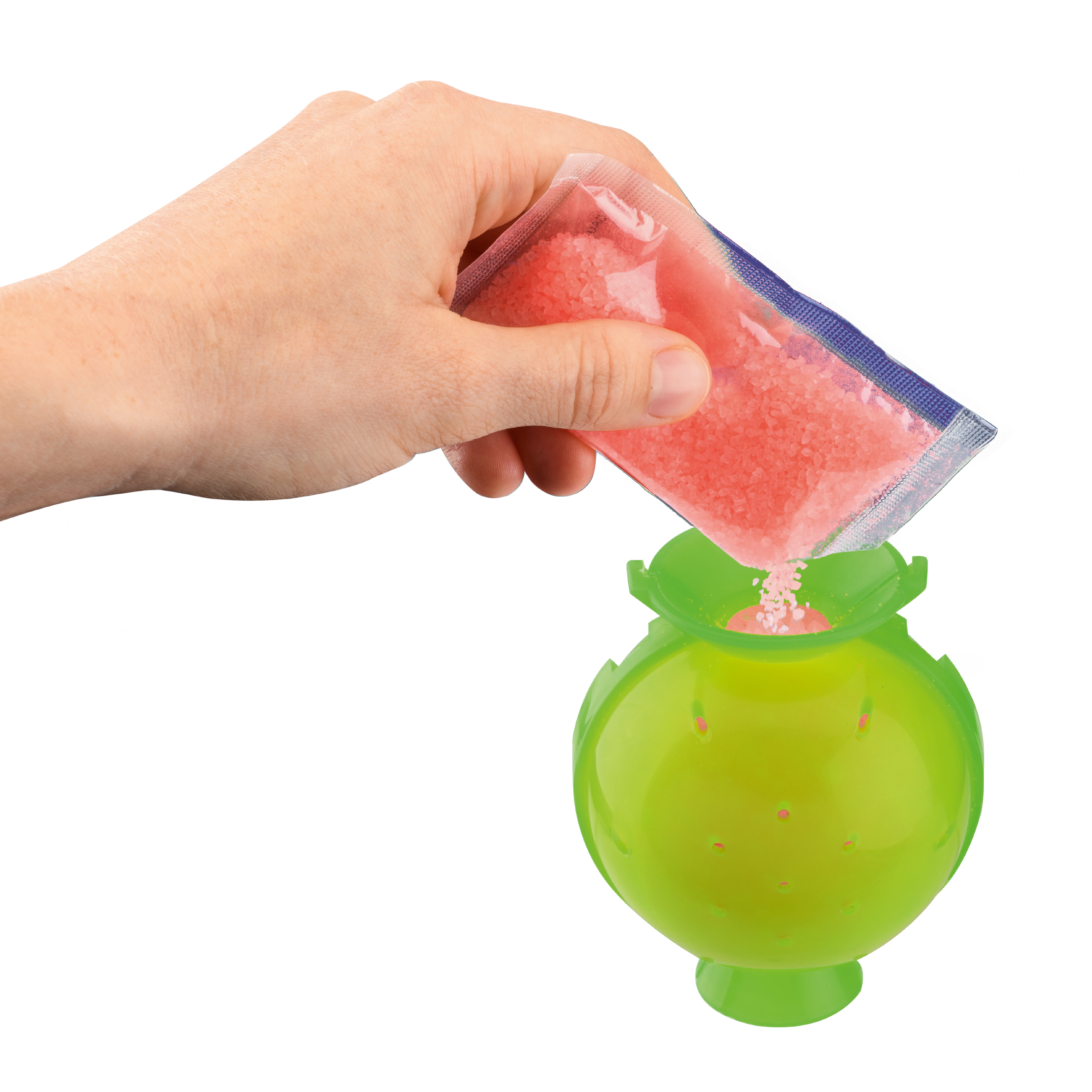 Una mano versa sali da bagno rosa da un pacchetto in un contenitore verde.