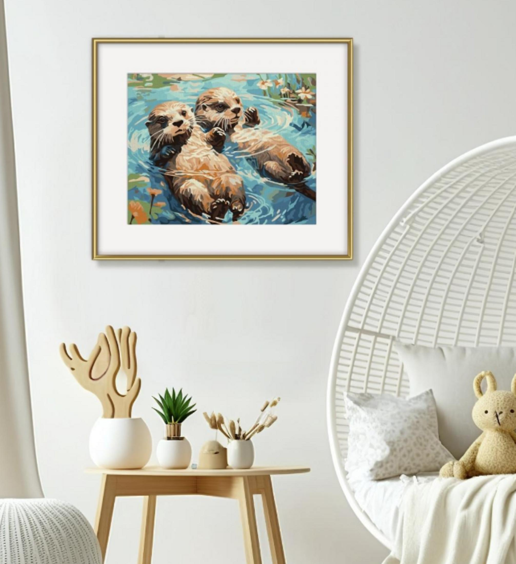 Ein gerahmtes Otter-Gemälde hängt über einem Holztisch mit Pflanzenvasen neben einem weißen Rattansessel.