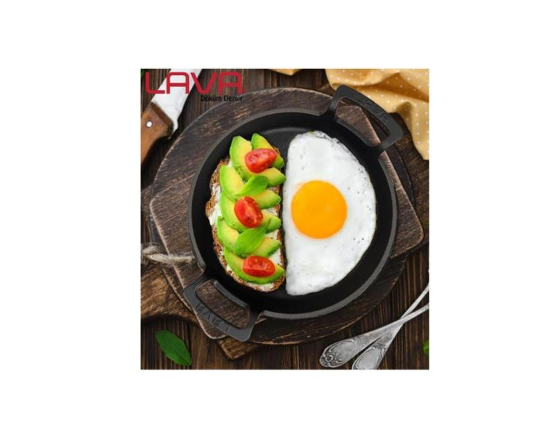 Tahta üzerinde sahanda yumurta ve avokadolu domatesli tost olan siyah bir tava.