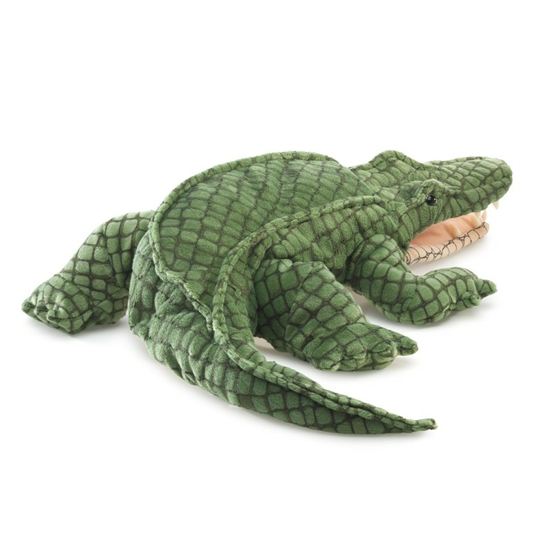 Une peluche alligator verte avec une bouche ouverte sur fond blanc.