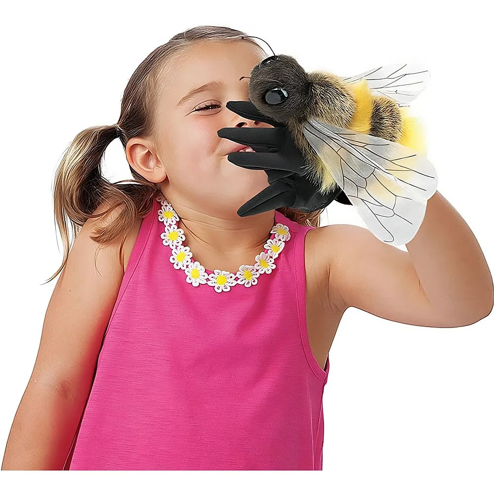 Une jeune fille en haut rose joue avec une grande marionnette abeille en peluche.