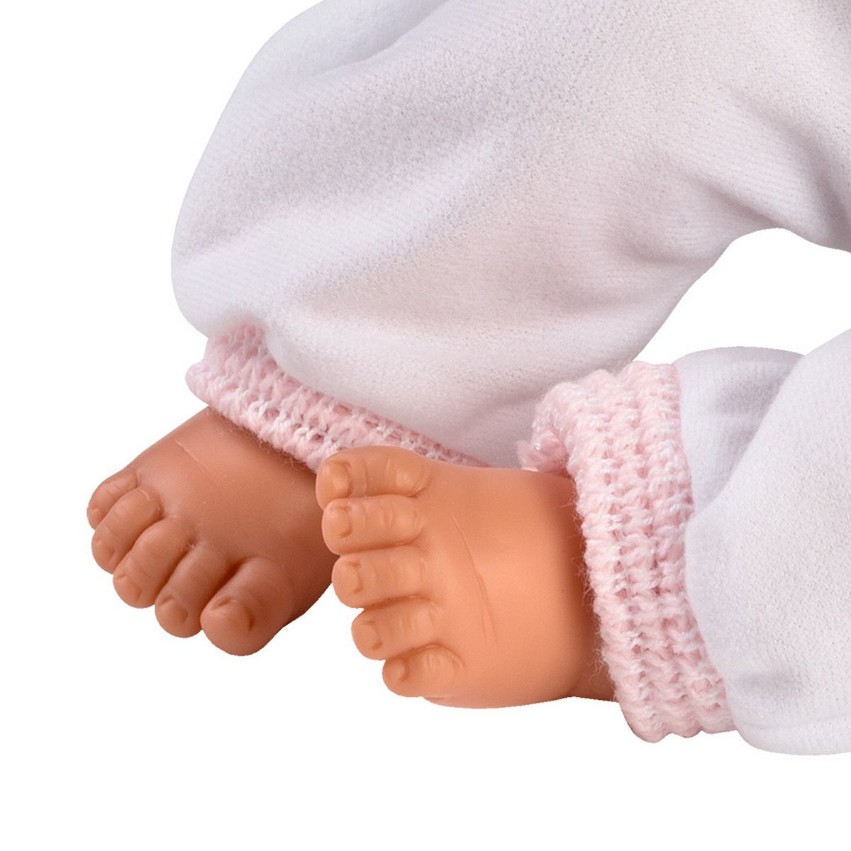 Primo piano dei piedi di una bambola che indossa pantaloni bianchi con polsini rosa lavorati a maglia.